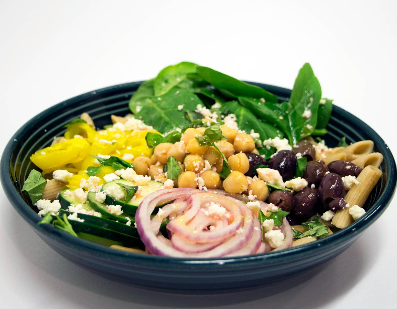 Power bowl with greens, pasta, chickpeas, black beans, peppers, and onions.